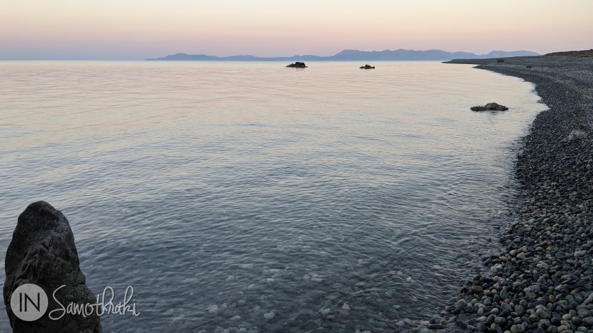 Apusul proiectează asupra mării și asupra insulei Gokceada o lumină diafană, cu nuanțe rozalii